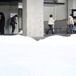 多くの積雪を横目に、期日前投票所に向かう有権者ら＝豊岡市中央町