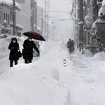 大雪の中、豊岡市街を歩く人ら＝８日午後、同市中央町（撮影・大高　碧）