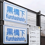 ３枚の「黒橋下」の標識が並ぶ。表面の塗料や素材を変えて耐久性を調べる＝明石市大蔵町