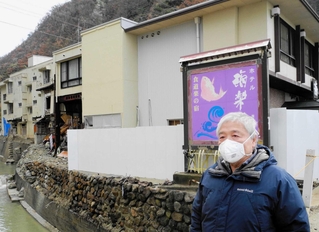 被災したホテル海楽荘の青石綿露出の状況を説明する永倉冬史さん＝２０２５年１２月、石川県珠洲市