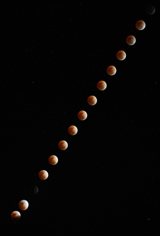 赤銅色で空に上がっていく皆既食中の月＝３日午後８時１分から５分間隔で撮影した１８枚を合成、兵庫県佐用町の大撫山から（撮影・大田将之）