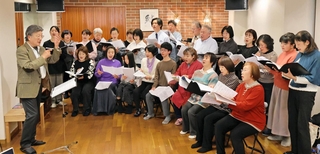 東日本大震災15年に合わせ、22日に開くコンサートに向けて練習する檀美知生さん（左端）ら団員たち＝芦屋市宮塚町