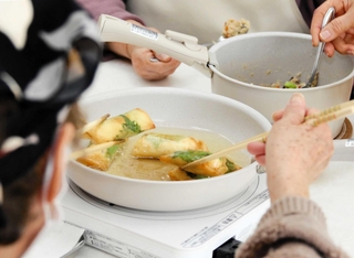 揚げ物やあえ物など多彩な献立にチャレンジする利用者＝神戸市須磨区車
