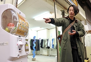 モトコーにちなんだポーチが入るガチャガチャを紹介する森山未來さん＝神戸市中央区元町高架通（撮影・長嶺麻子）