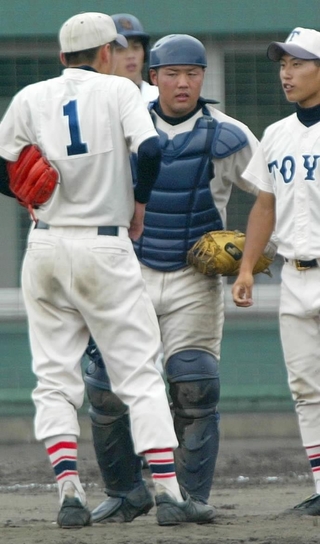 全国高校野球兵庫大会で、アン投手（背番号１）と話す菰方さん（右から２人目）＝２００３年７月、明石球場