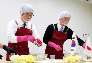 兵庫県産のハクサイを使ってキムチ作りを体験する斎藤元彦知事（右）と李相烈・駐神戸韓国総領事＝神戸市長田区腕塚町５