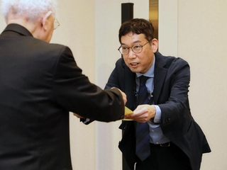 賞状を受け取る高田康夫記者（右）＝２５日午後、大阪市北区