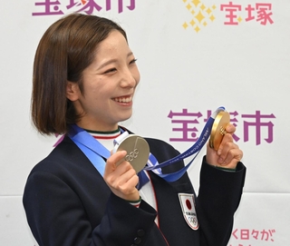 宝塚市役所を訪れ、金銀のメダルを手にする三浦璃来選手＝３月２日、宝塚市東洋町