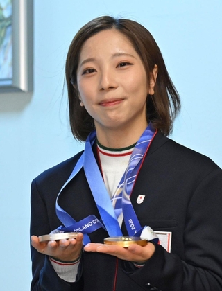 宝塚市役所を訪れ、金銀のメダルを大事そうに持つ三浦璃来選手＝３月２日、宝塚市東洋町