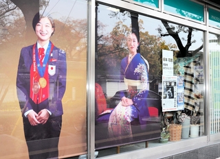 フォトスタジオ八木の窓ガラスには、坂本花織選手の大きな写真が飾られている＝２８日午後、神戸市中央区多聞通４