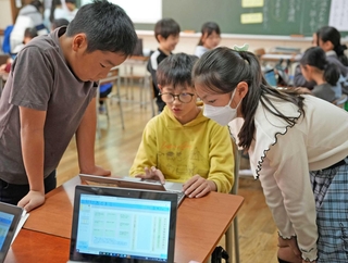 端末を囲んで議論する児童たち＝神戸市立東町小学校