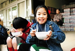 炊き出しのみそ汁に喜ぶ子ども。非常食など備蓄の大切さに気付かされた＝１９９５年１月２５日、神戸市東灘区深江本町