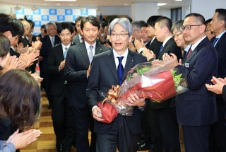 花束を手に職員らに拍手で見送られる服部洋平副知事＝３１日午後、神戸市中央区、兵庫県庁（撮影・丸山桃奈）