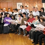 東日本大震災15年に合わせ、22日に開くコンサートに向けて練習する檀美知生さん（左端）ら団員たち＝芦屋市宮塚町