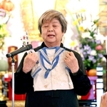 神戸空襲で犠牲になった兄遠藤吉信さんの服を手に語る金川佐智子さん＝１７日午後、神戸市兵庫区、薬仙寺（撮影・丸山桃奈）