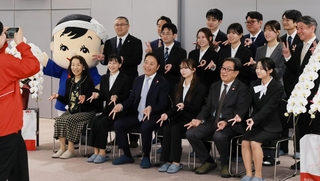 カネテツデリカフーズの入社式で、カニになぞらえたポーズで記念写真に納まる新入社員と役員ら＝１日午前、神戸市東灘区向洋町西５（撮影・鈴木雅之）