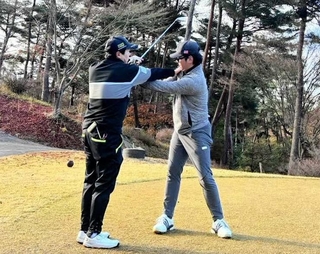 参加者にスイングを指導する男子プロ（左）＝加東市上三草、高室池ゴルフ倶楽部（提供）