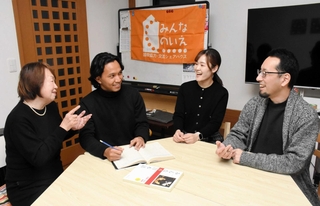 設立から５年が経過した「みんなのいえ」で談笑する坂西卓郎事務局長（右端）や、チャンドラ・プラタマ・ウィジャヤさん（左から２人目）ら＝神戸市長田区神楽町３