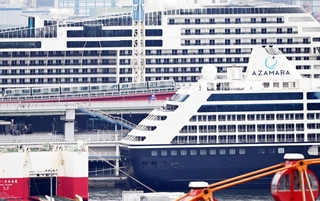 巨大リゾートホテルのように見える２隻の豪華客船。その間をポートライナーが通過した＝９日午前、神戸市中央区東川崎町１から撮影