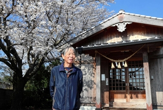 熊本地震後に再建した地域の神社の拝殿を背に、当時を振り返る東無田地区の宮永和典さん＝熊本県益城町島田
