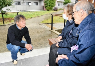 災害公営住宅に住む土田伊津雄さん（右）と妻朱美さんに健康状態などを尋ねる高木聡史さん（左）＝熊本県益城町安永