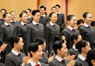 先輩らに拍手で迎えられる新入生たち＝１８日午前、宝塚音楽学校