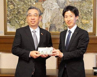 来県記念として姫路城をデザインした革製品をホーチミン市のグエン・フオック・ロック共産党委員会副書記（左）に手渡す守本豊副知事＝兵庫県公館