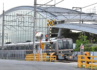 脱線事故現場付近を通過する電車＝２５日午前６時８分、尼崎市久々知３（撮影・斎藤雅志）