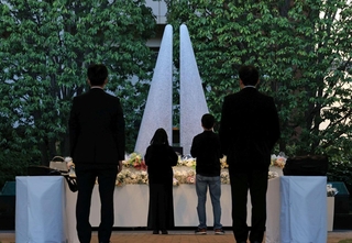 追悼施設「祈りの杜」では、日が暮れた後も献花の列が続いた＝２５日午後６時２４分、尼崎市久々知３（撮影・丸山桃奈）