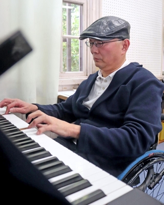 尼崎ＪＲ脱線事故で亡くなった石井勝さんの形見であるピアノを初めて弾く、兄の努さん＝25日午後、三田市南が丘２