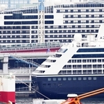 巨大リゾートホテルのように見える２隻の豪華客船。その間をポートライナーが通過した＝９日午前、神戸市中央区東川崎町１から撮影