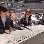 朝刊紙面を広げ、研修に取り組む新人職員ら＝神戸市東灘区向洋町中６