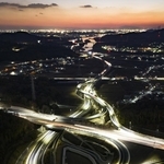 東・北播磨地域をつなぐ東播磨道の小野ランプ。夕暮れに、光の道が浮かび上がった＝小野市池尻町（ドローンで撮影）