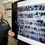 車中泊避難者の車で埋まったグラウンドの写真を前に熊本地震を振り返る吉永浩伸さん＝熊本市中央区手取本町