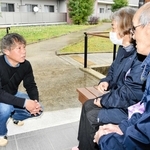 災害公営住宅に住む土田伊津雄さん（右）と妻朱美さんに健康状態などを尋ねる高木聡史さん（左）＝熊本県益城町安永