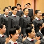 先輩らに拍手で迎えられる新入生たち＝１８日午前、宝塚音楽学校