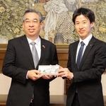 来県記念として姫路城をデザインした革製品をホーチミン市のグエン・フオック・ロック共産党委員会副書記（左）に手渡す守本豊副知事＝兵庫県公館