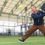 ガラスに跳ね返ったボールを打ち返す沓名舞子さん＝尼崎市南城内、パデル道場