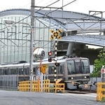 脱線事故現場付近を通過する電車＝２５日午前６時８分、尼崎市久々知３（撮影・斎藤雅志）