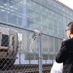 事故現場のフェンスに献花し、手を合わせる男性＝２５日午前７時４７分、尼崎市久々知３（撮影・吉田敦史）