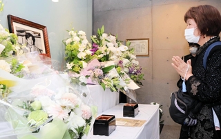 小尻知博記者の遺影に手を合わせる市民＝３日午後、西宮市与古道町、朝日新聞阪神支局