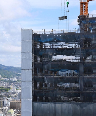 街並みにそびえ立つように建設中の神戸三宮ツインゲート１期ビル＝神戸市中央区雲井通７から