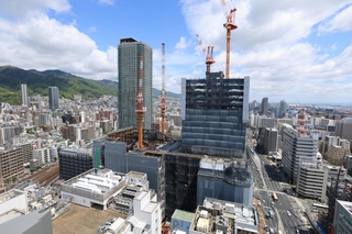 街並みにそびえ立つように建設中の神戸三宮ツインゲート１期ビル＝神戸市中央区雲井通７から