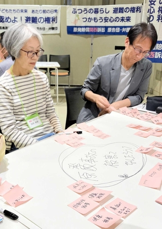 それぞれの思いを書いた付箋を前に意見交換する参加者ら＝大阪市中央区、ドーンセンター