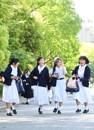 伝統の白い夏服を着て登校する生徒たち＝１１日午前、神戸市灘区王子町（撮影・斎藤雅志）