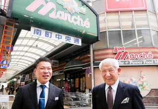 銀ビルストアーが運営するスーパー「ボンマルシェ」前に立つ大塚兼史社長（左）と７０年の歩みを支えた岡田輝年相談役＝姫路市南町