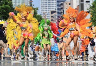 夏のような日差しでかげろうが揺らめく中、サンバを踊るパレードの参加者＝１７日午後、神戸市中央区（撮影・鈴木雅之）