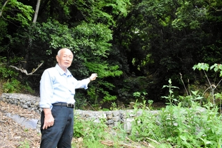 土石流が発生した斜面を背に当時の状況を説明する大重昭司さん＝８日午前、神戸市灘区篠原台