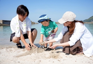 ３５・３度の猛暑日となった豊岡。海岸では親子連れが早速、水遊びを楽しんだ＝１８日午後３時４分、豊岡市竹野町竹野（撮影・吉田みなみ）