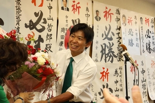 当選の知らせを受け、事務所で花束を受け取る中山哲郎氏＝稲美町国安